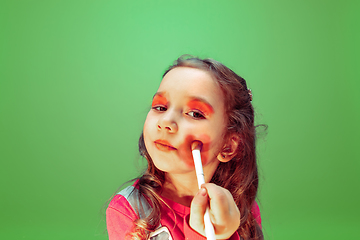 Image showing Little girl dreaming about future profession of makeup and hairstyle artist