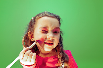 Image showing Little girl dreaming about future profession of makeup and hairstyle artist