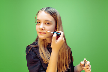 Image showing Little girl dreaming about future profession of makeup and hairstyle artist