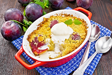 Image showing Crumble with plum and ice cream in brazier on dark board