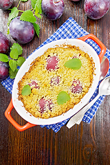 Image showing Crumble with plum in brazier on dark board top