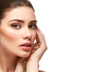 Image showing girl applying moisturizing cream isolated on white