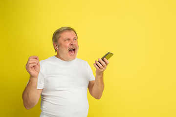 Image showing Caucasian senior man\'s portrait isolated on yellow studio background