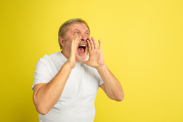 Image showing Caucasian senior man\'s portrait isolated on yellow studio background