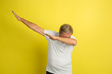 Image showing Caucasian senior man\'s portrait isolated on yellow studio background