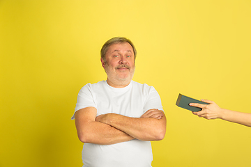 Image showing Caucasian senior man\'s portrait isolated on yellow studio background