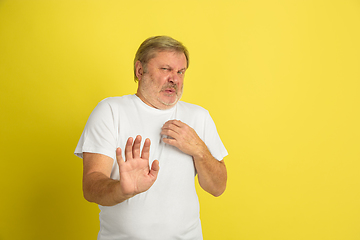 Image showing Caucasian senior man\'s portrait isolated on yellow studio background