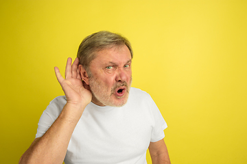 Image showing Caucasian senior man\'s portrait isolated on yellow studio background