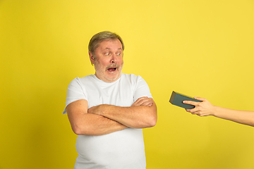 Image showing Caucasian senior man\'s portrait isolated on yellow studio background