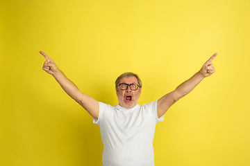 Image showing Caucasian senior man\'s portrait isolated on yellow studio background