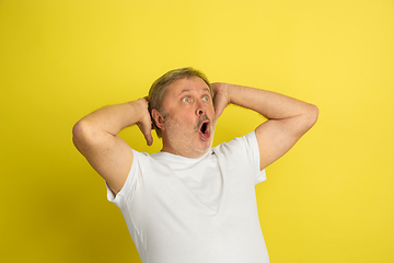 Image showing Caucasian senior man\'s portrait isolated on yellow studio background