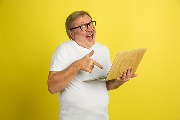 Image showing Caucasian senior man\'s portrait isolated on yellow studio background