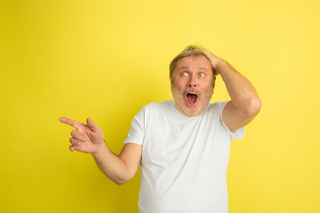 Image showing Caucasian senior man\'s portrait isolated on yellow studio background