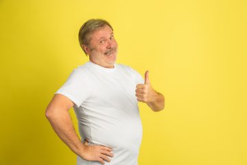 Image showing Caucasian senior man\'s portrait isolated on yellow studio background