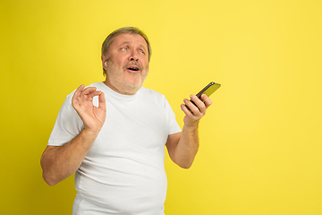 Image showing Caucasian senior man\'s portrait isolated on yellow studio background