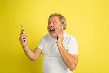 Image showing Caucasian senior man\'s portrait isolated on yellow studio background