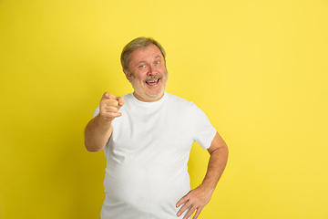 Image showing Caucasian senior man\'s portrait isolated on yellow studio background