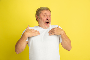 Image showing Caucasian senior man\'s portrait isolated on yellow studio background