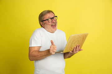 Image showing Caucasian senior man\'s portrait isolated on yellow studio background