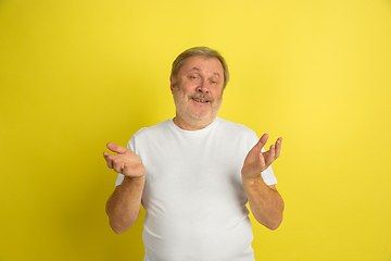 Image showing Caucasian senior man\'s portrait isolated on yellow studio background