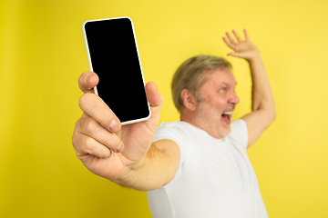 Image showing Caucasian senior man\'s portrait isolated on yellow studio background