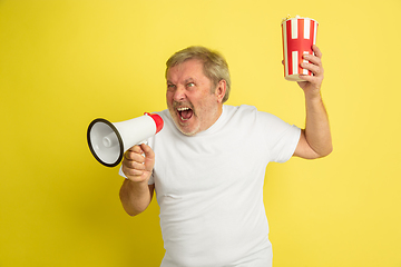 Image showing Caucasian senior man\'s portrait isolated on yellow studio background