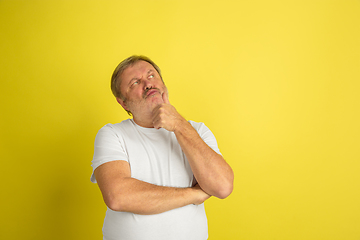 Image showing Caucasian senior man\'s portrait isolated on yellow studio background