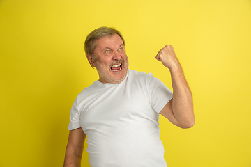 Image showing Caucasian senior man\'s portrait isolated on yellow studio background