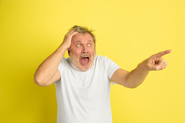 Image showing Caucasian senior man\'s portrait isolated on yellow studio background