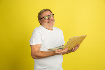 Image showing Caucasian senior man\'s portrait isolated on yellow studio background