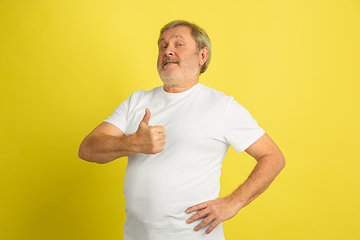 Image showing Caucasian senior man\'s portrait isolated on yellow studio background