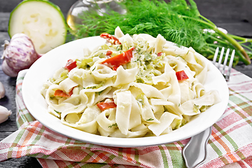 Image showing Fettuccine with zucchini and hot peppers in plate on dark board