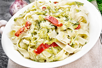 Image showing Fettuccine with zucchini and hot peppers in plate on dark wooden