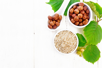 Image showing Flour and hazelnuts in bowls on board top