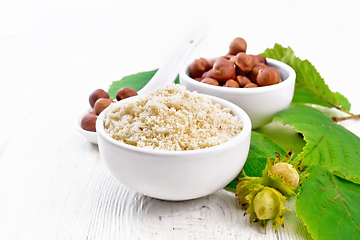 Image showing Flour and hazelnuts in bowls on white board