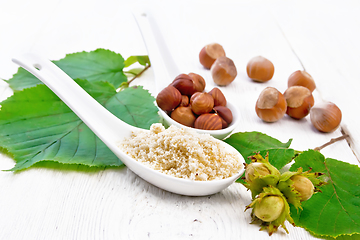 Image showing Flour and hazelnuts in spoons on light board