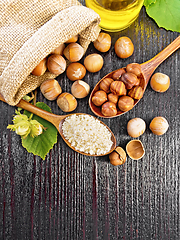 Image showing Flour and hazelnuts in two spoons on dark board top