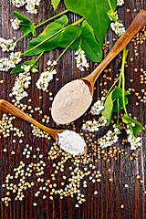 Image showing Flour buckwheat brown and green in spoons on dark board top