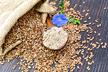 Image showing Flour flax in spoon with seeds and flower on board