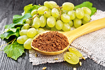 Image showing Flour grape seed in spoon on dark board