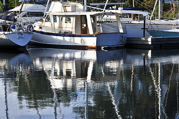 Image showing Moored sailboats reflecting in water