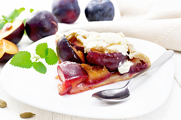 Image showing Galeta with plums in plate on white wooden board