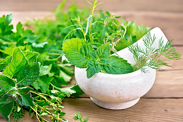 Image showing Herbs spicy in stone mortar on wooden board