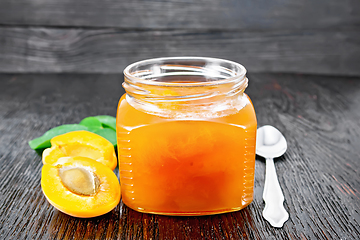 Image showing Jam apricot in jar on wooden board