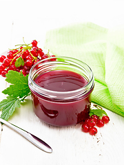 Image showing Jam of red currant in jar on wooden board