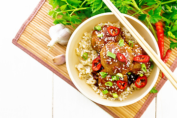 Image showing Meatballs in sweet and sour sauce with rice on board top