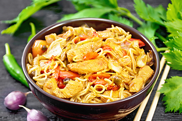 Image showing Noodles with cabbage and chicken in bowl on black board