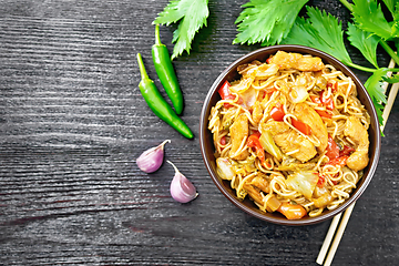 Image showing Noodles with cabbage and chicken in bowl on dark board top