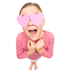 Image showing Little girl is holding hearts over her eyes