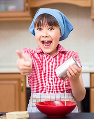 Image showing Girl is cooking in kitchen